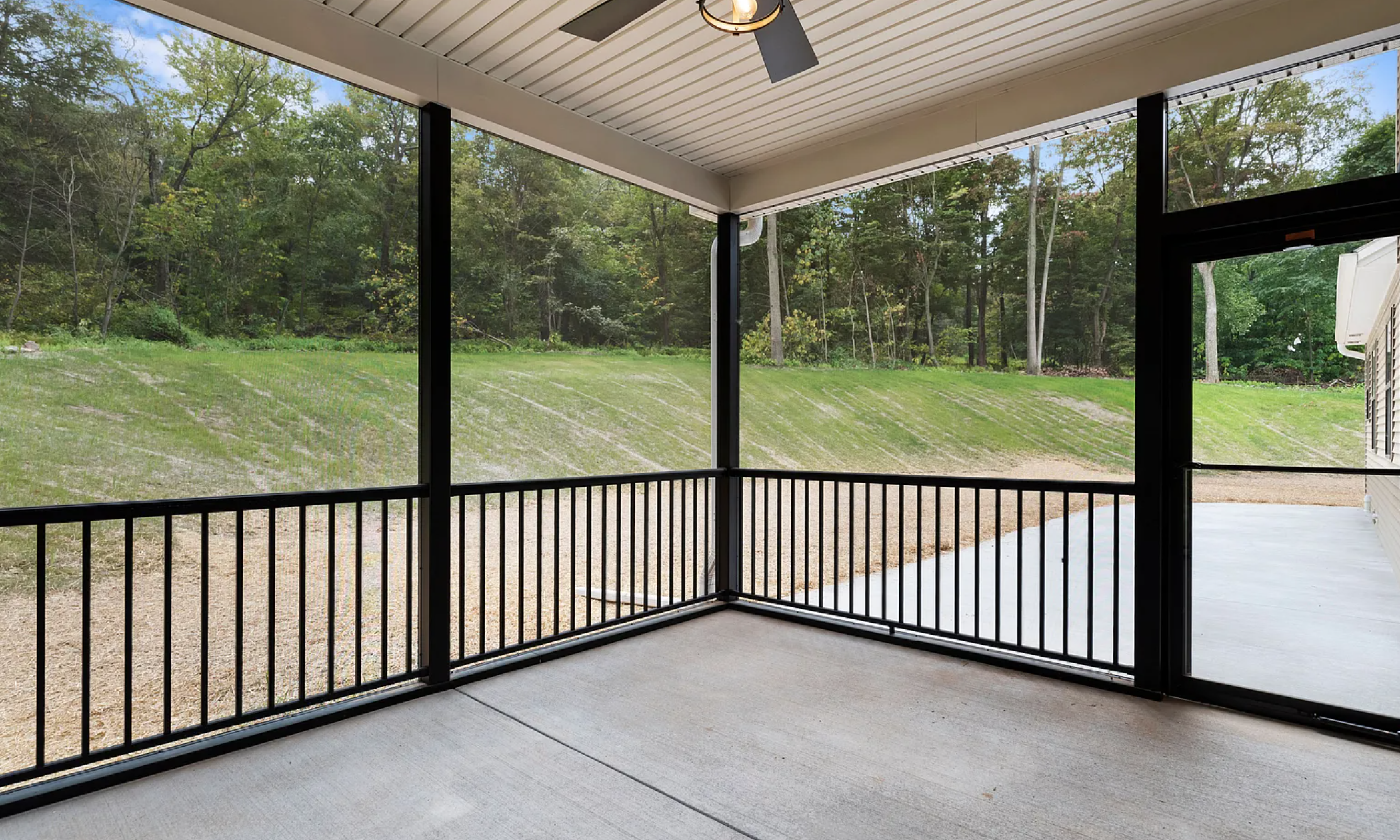 Outdoor screened-in porch with ceiling fan in a Rockville Estates home by Yingst Building Group in Marysville, Pennsylvania