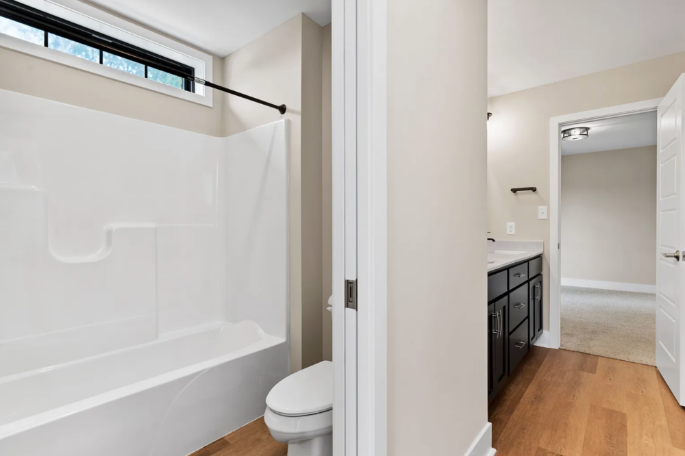 Full bathroom with bathtub, toilet, and vanity in a Rockville Estates home by Yingst Building Group